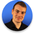 Portrait of a young man in a black shirt against a blue background
