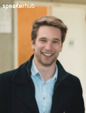 Smiling young man in a dark coat and light blue shirt